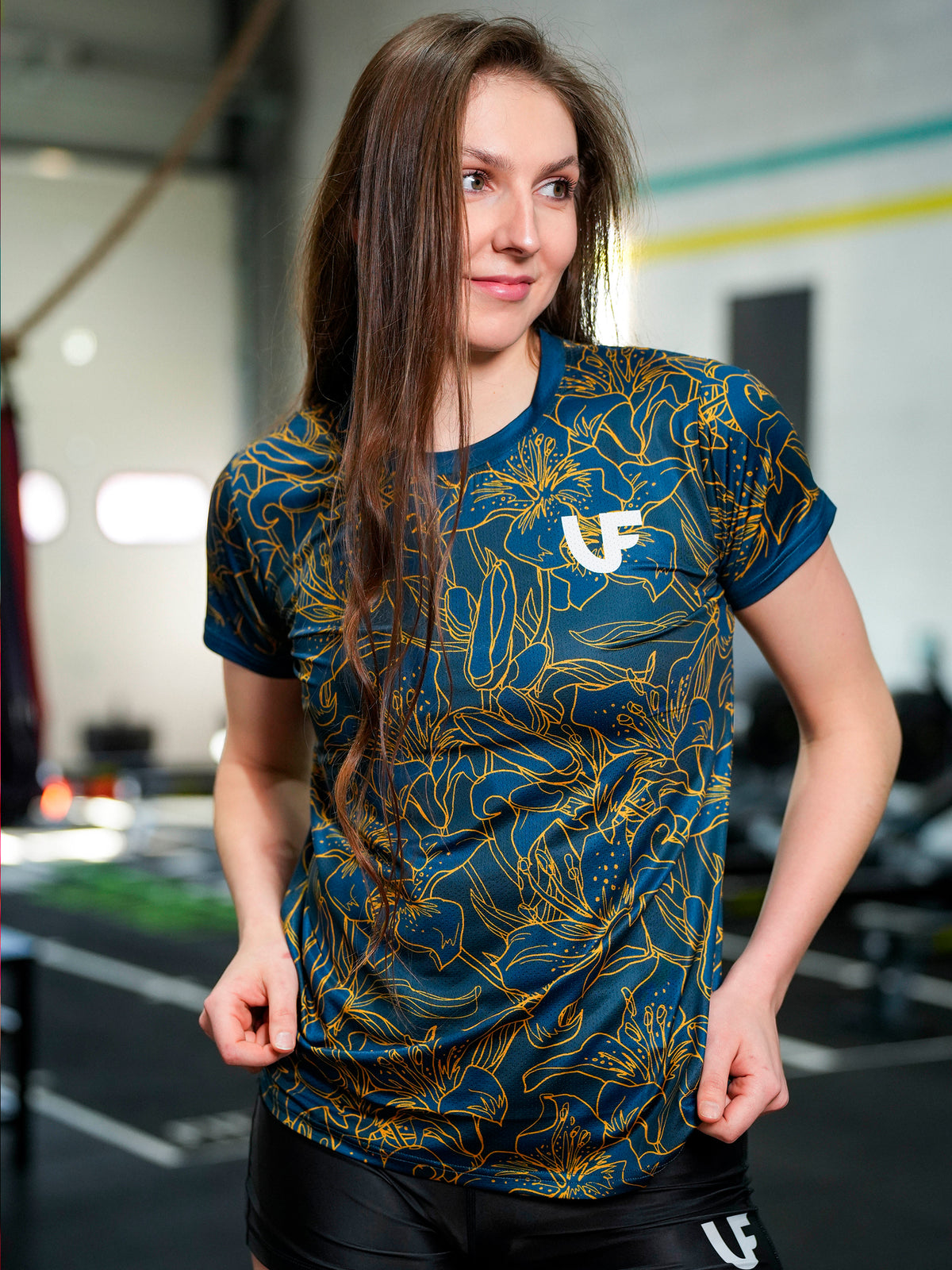 Mannequin souriant avec t-shirt de sport bleu à motifs fleurs pour femme LVF Gold Flowers