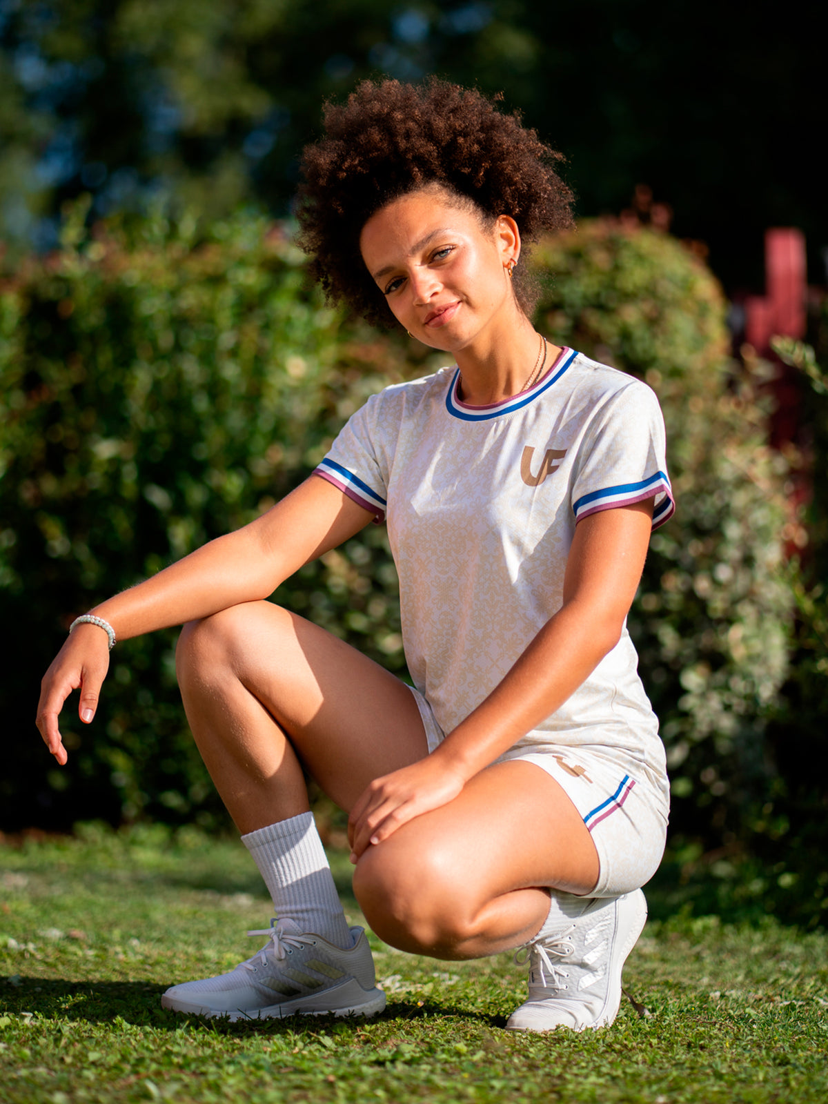 Athlète accroupie en T-shirt de sport beige femme et short beige LVF Héritage