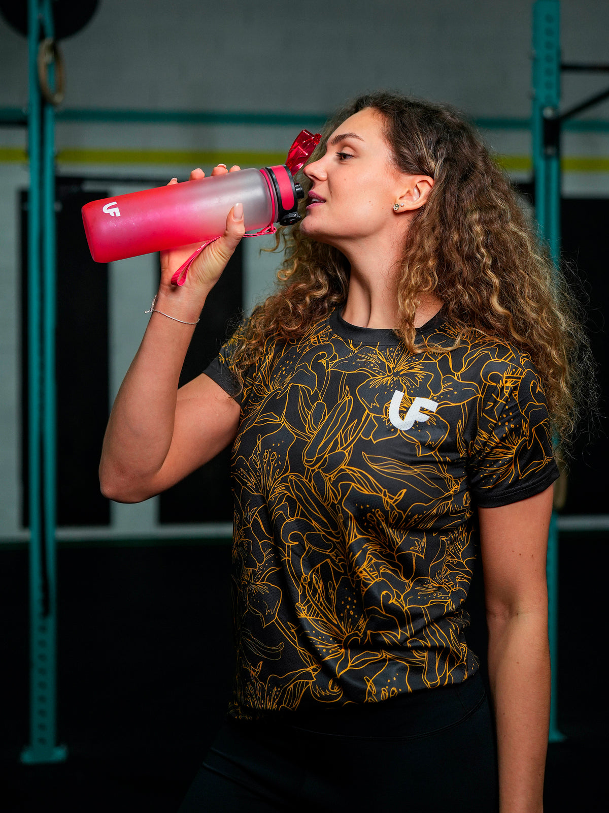 Sportive qui boit en t-shirt de sport noir à motifs fleurs pour femme LVF Gold Flowers