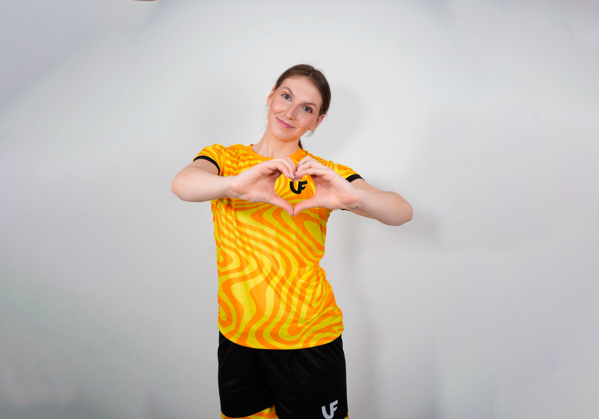 Mannequin faisant un coeur autour du logo LVF du t-shirt de sport jaune Break The Lines