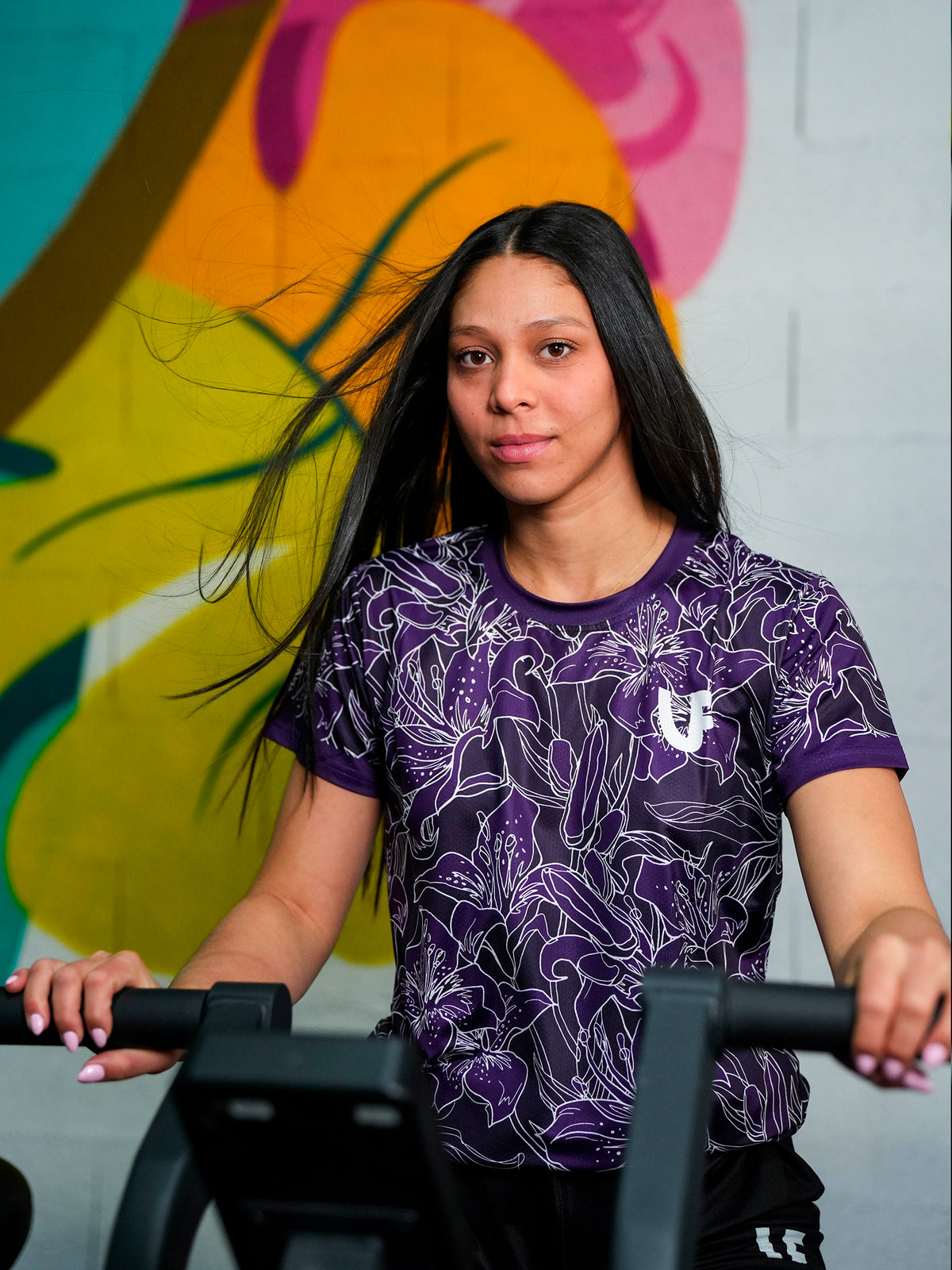 Sportive sur vélo elliptique avec t-shirt de sport violet et blanc à motifs fleurs pour femme LVF Gold Flowers