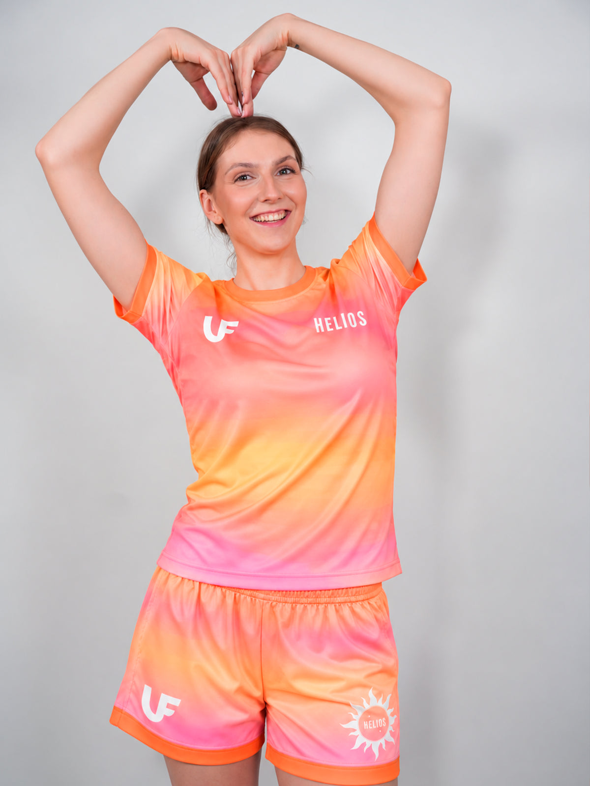 Mannequin qui fait un coeur avec ses mains en tenue de sport LVF rose et orange